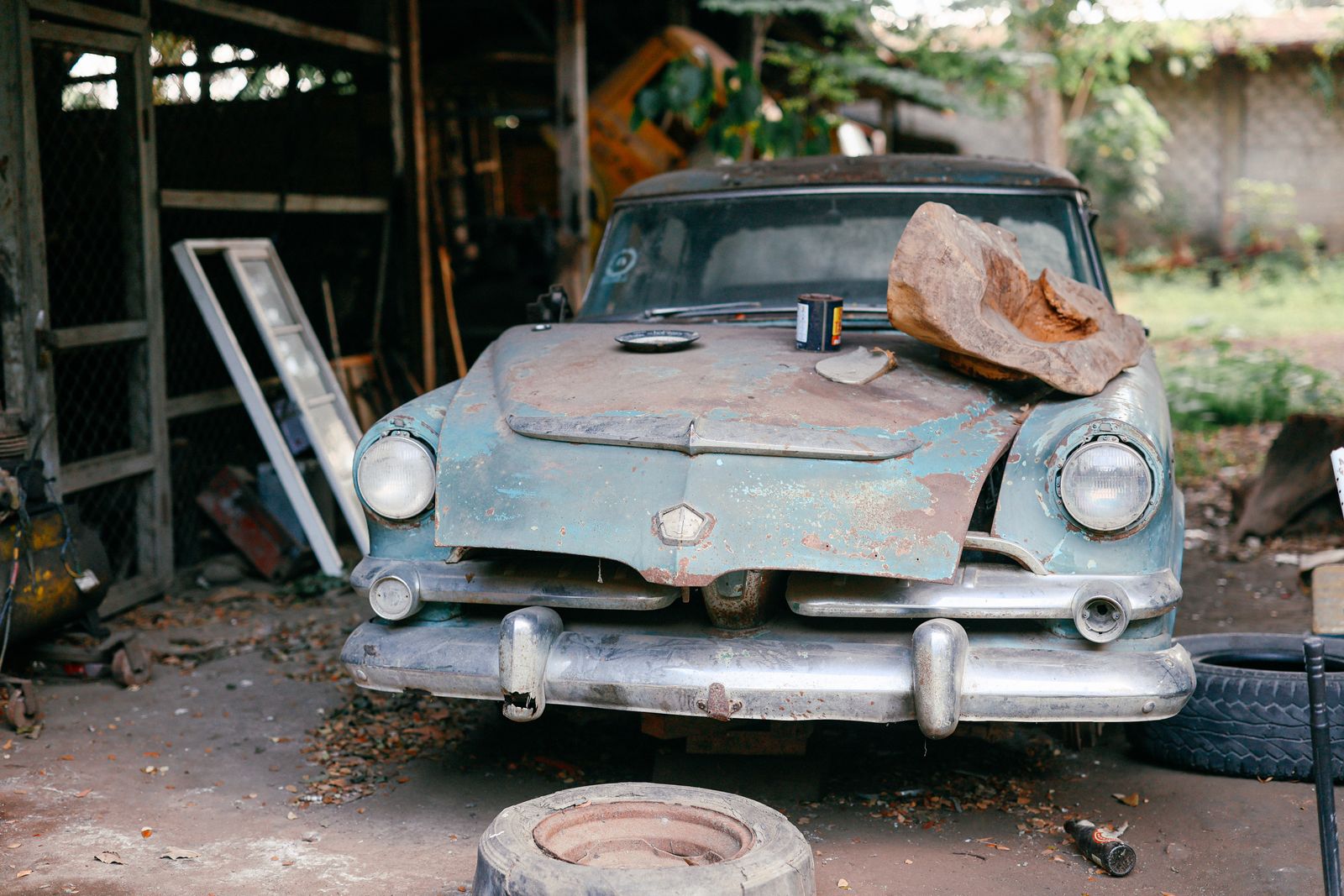 Abandoned Vintage Car in Rustic Workshop Setting