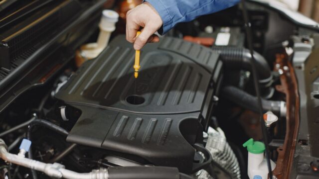 Person Checking the Oil of an Engine